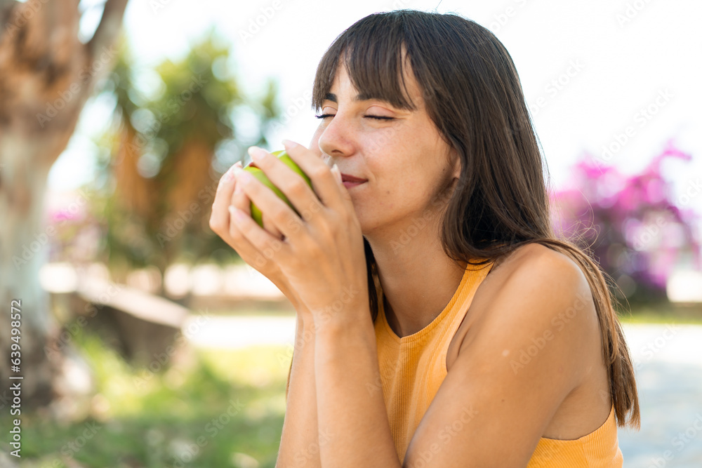 Young woman at outdoors holding an apple Young woman at outdoors holding an apple