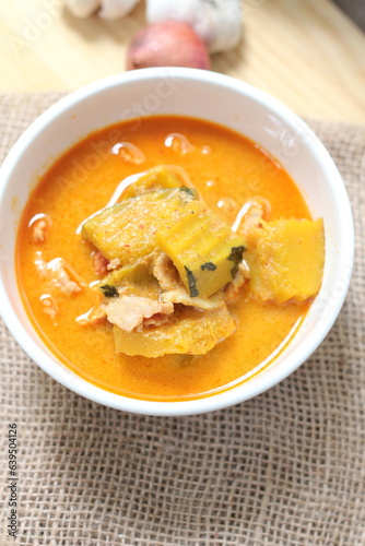 Red Curry Pumpkin with Chicken served on wooden table, delicious Thai food popular in Thailand, Asia food.