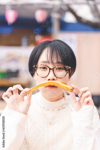 Japan travel on spring with sakura vertical portrait asian woman eating potato fries japanese tasty