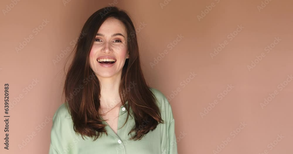Girl showing thumbs up, like sign. Positive something good has happened finger gesture for fine result well done. Young attractive woman wear green shirt, brunette hair, isolated on beige background. Girl showing thumbs up, like sign. Positive something good has happened finger gesture for fine result well done. Young attractive woman wear green shirt, brunette hair, isolated on beige background.