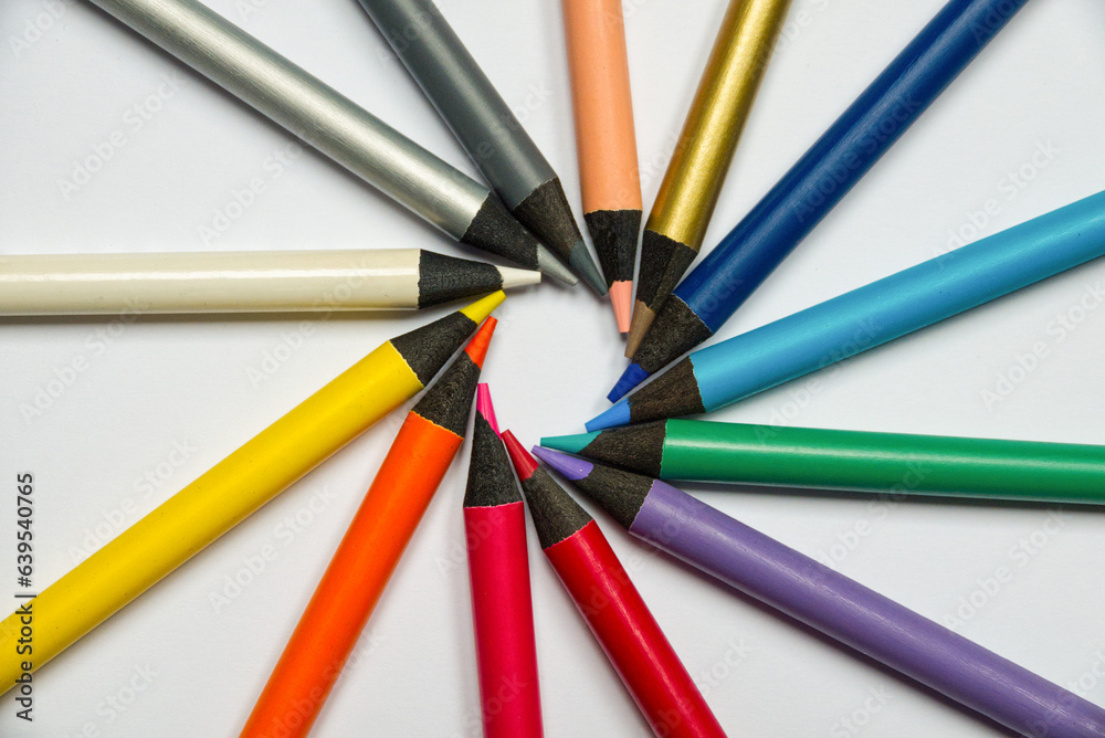 Different colored crayons with letters arranged in a circle on white background. High quality photo Different colored crayons with letters arranged in a circle on white background. High quality photo