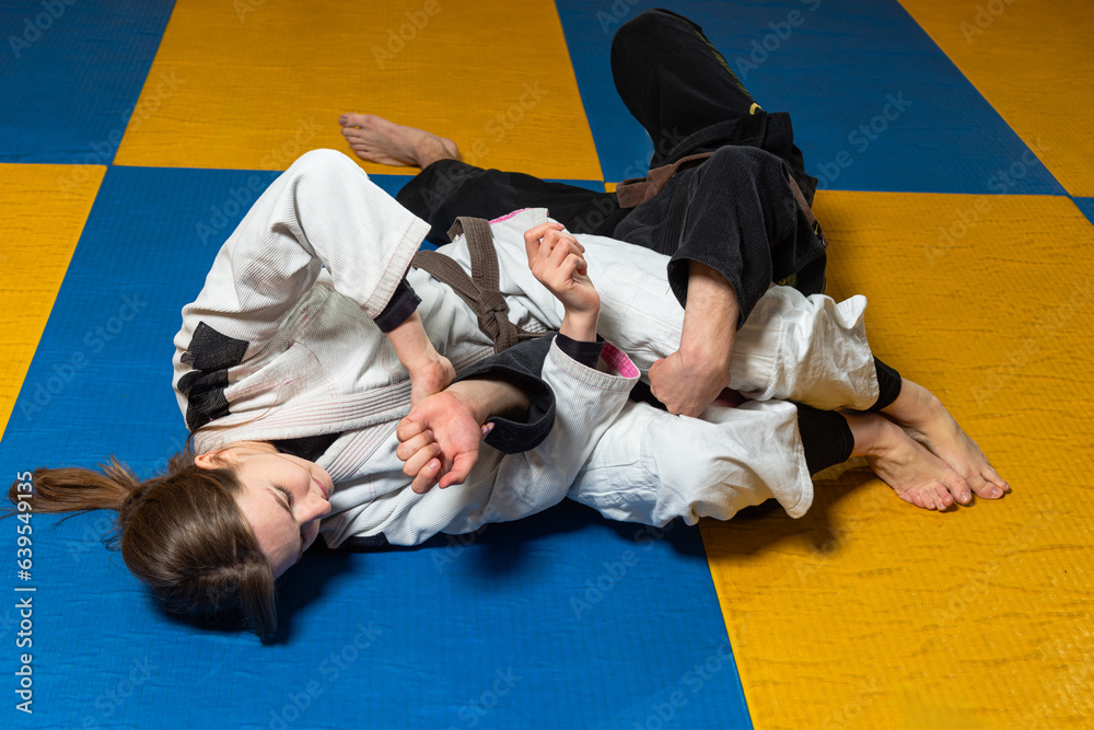 Young girl and boy practice Brazilian jiu jitsu in the gym Young girl and boy practice Brazilian jiu jitsu in the gym