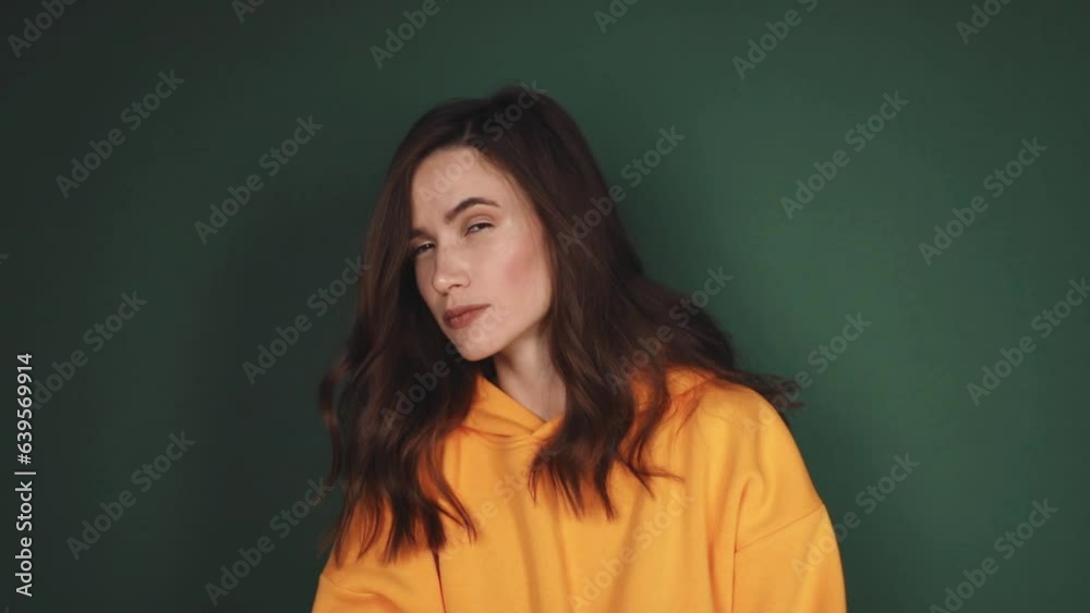Suspiciously lady make eye contact gesture sign, I see you. Attractive brunette woman wear yellow hoody isolated on green background. I'm looking for you. Suspiciously lady make eye contact gesture sign, I see you. Attractive brunette woman wear yellow hoody isolated on green background. I'm looking for you.