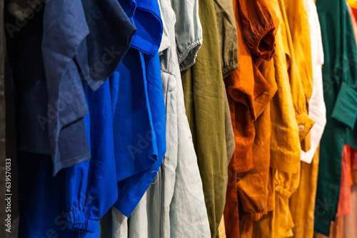 Multi-colored clothes hanging on hangers made of cotton fabric
