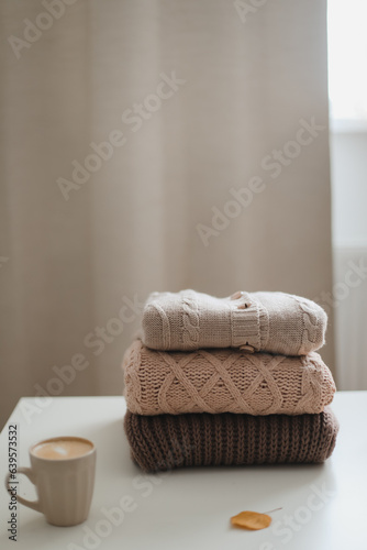 Fototapeta Naklejka Na Ścianę i Meble -  cozy comfortable hygge home atmosphere and still life with a cup, candle, book and sweaters