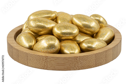 golden almond dragees in a wooden bowl