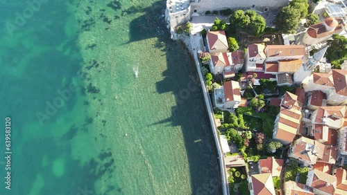 A camera drone flies sidewise over Budva Old Town and Ričardova Glava beach photo