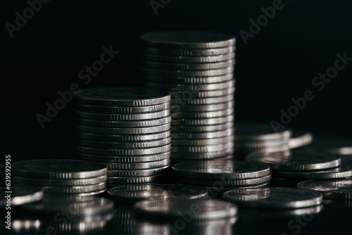 Silver money coin stack on black background with selective focus. Business and financial background.