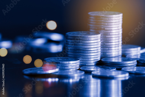 Money coin stack on black background with blue filter. Business and finance concept.