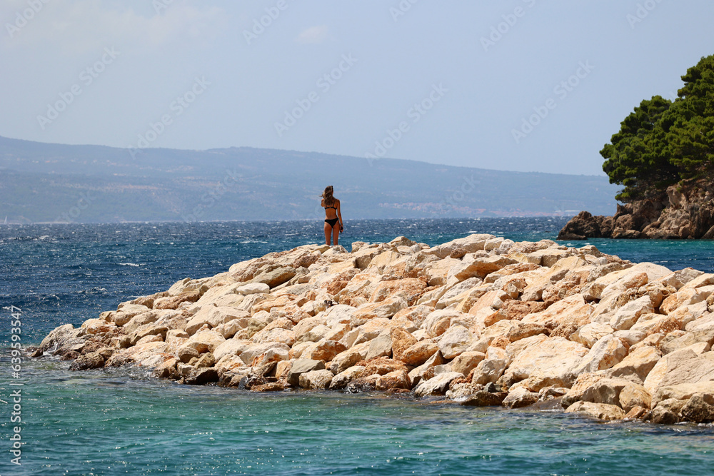 Obraz premium Piękna dziewczyna stoi na słonecznej wyspie na morzu. 