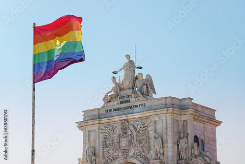 Pride flag in Lisbon, Portugal. Rainbow flag, LGBT flag on Praça do Comércio, Commerce square in front of Rua Augusta Arch, Arco da Rua Augusta. Pride month in June.  photo