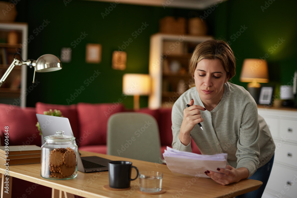 Pensive women using laptop at home office to check her finances