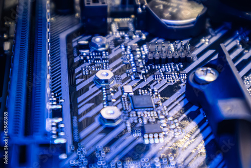 Motherboard with sockets close-up on modern powerful desktop PC. Computer hardware chipset components in blue light. Tech industry electronics background