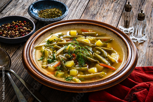 Green bean soup on wooden table
