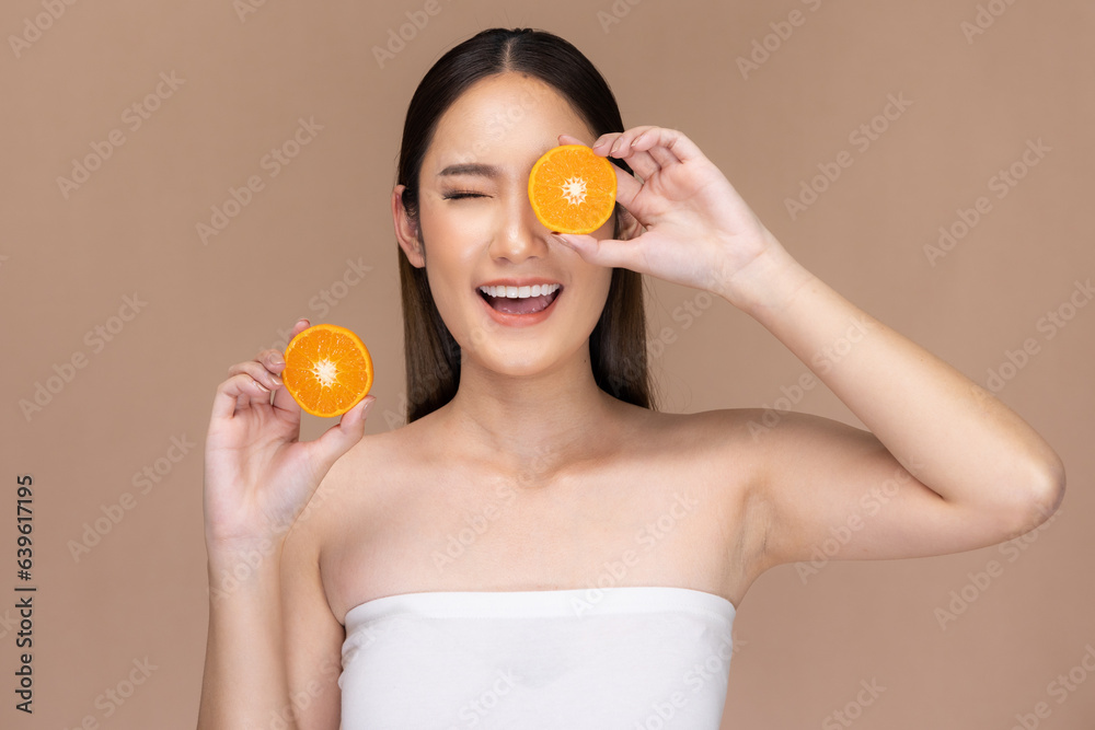 Beautiful Asian woman posing with orange and positive emotional,isolated on Beige background,Beauty Cosmetics and spa Facial treatment Concept. Beautiful Asian woman posing with orange and positive emotional,isolated on Beige background,Beauty Cosmetics and spa Facial treatment Concept.