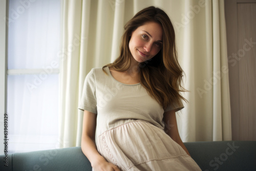Candid portrait of a young, pregnant woman in her living room, emotions of excitement and apprehension. The natural beauty of impending motherhood shines through in a comfortable setting at home.