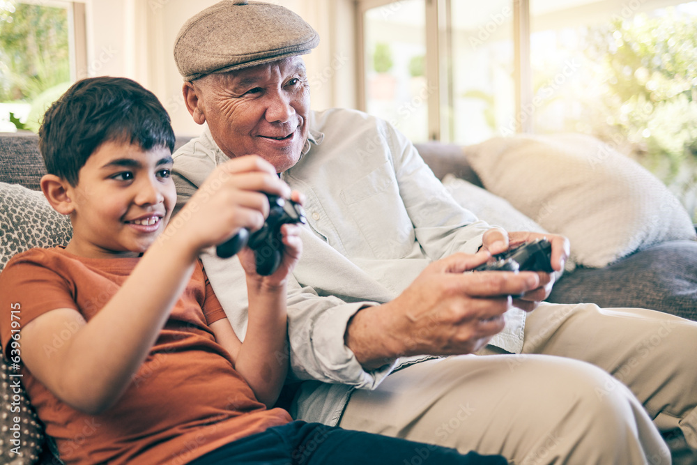 Family, fun and a boy gaming with his grandfather on a sofa in the living room of their home during a visit. Video game, children and a senior man learning how to play from his gamer grandson Family, fun and a boy gaming with his grandfather on a sofa in the living room of their home during a visit. Video game, children and a senior man learning how to play from his gamer grandson