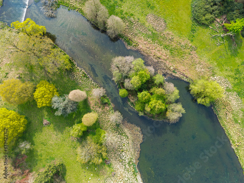 Aerial view of a pristine fresh water river seen flowing around a natural island  located in central England.