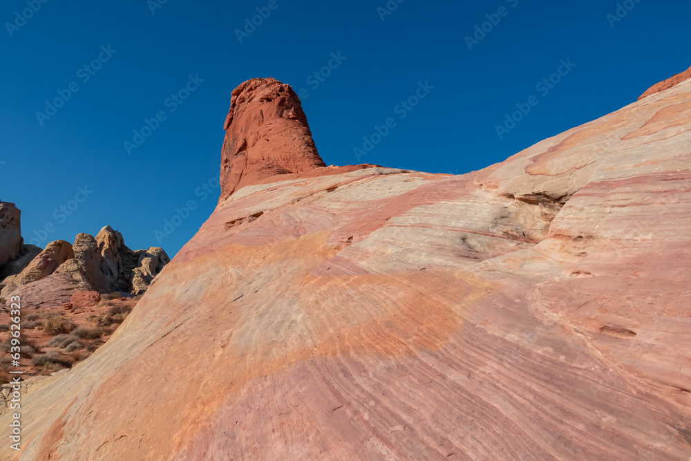 Scenic view of striated red and white rock formations along the White Domes Hiking Trail in Valley of Fire State Park in Mojave desert, Nevada, USA. Unique natural landmark shaped like a spire