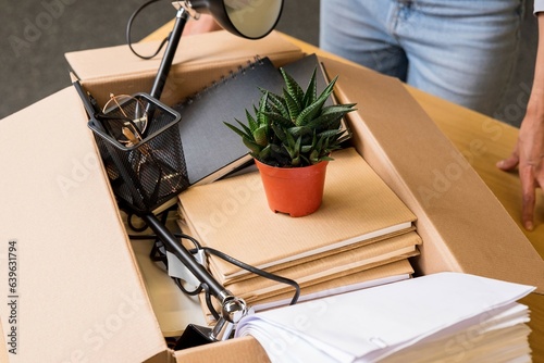 Unemployment and career concept. Box with personal office items is on the table, top view. Dismissal or job change. Office supplies assembled in a box photo