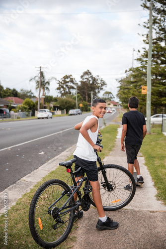 Aboriginal boy riding bike on footpath