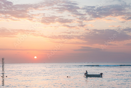 Fisherman boat in the ocean at sunset, Balangan beach, Bali, Indonesia photo
