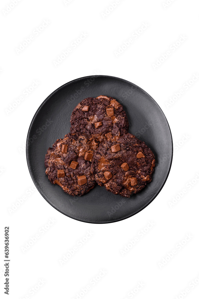 Delicious fresh oatmeal round cookies with chocolate on a black ceramic plate Delicious fresh oatmeal round cookies with chocolate on a black ceramic plate
