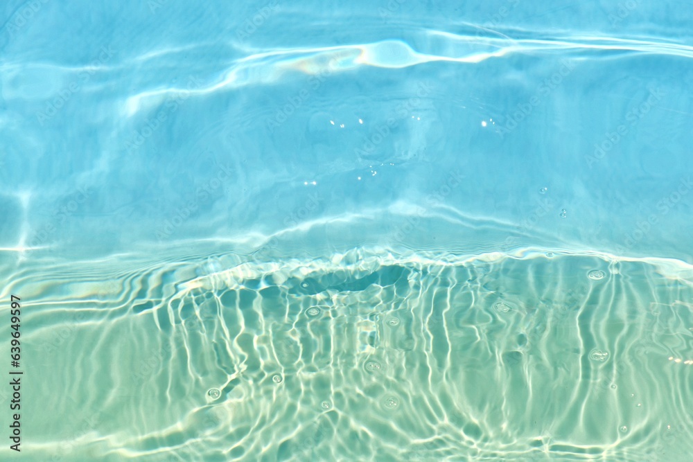 Blue water with ripples on the surface. Defocus blurred transparent blue colored clear calm water surface texture with splashes and bubbles. Water waves with shining pattern texture background. Blue water with ripples on the surface. Defocus blurred transparent blue colored clear calm water surface texture with splashes and bubbles. Water waves with shining pattern texture background.