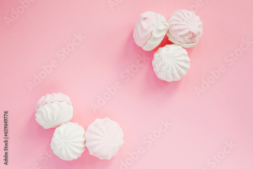 Soft marshmallows on a pink background, top view. Stylish dessert concept with space for text