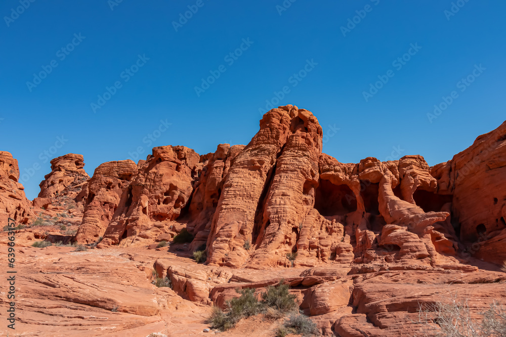 Exterior view of windstone arch and fire cave in Valley of Fire State Park, Mojave desert, Nevada, USA. Scenic view of beehive shaped red sandstone rock formations. Barren deserted landscape in summer