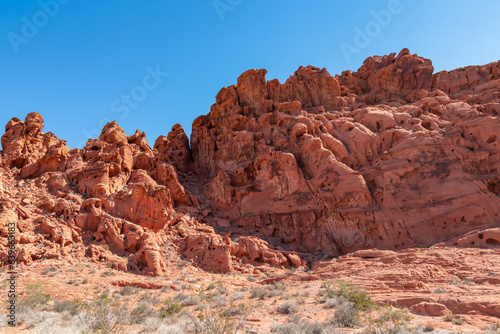 Exterior view of windstone arch and fire cave in Valley of Fire State Park, Mojave desert, Nevada, USA. Scenic view of beehive shaped red sandstone rock formations. Barren deserted landscape in summer © Chris