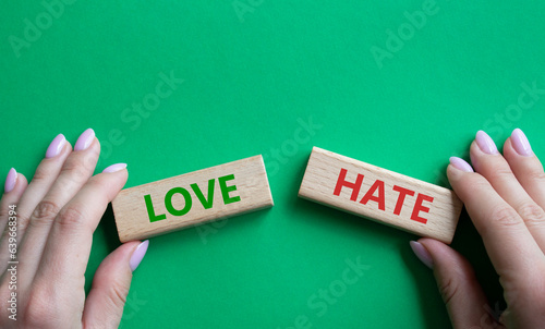 Love vs Hate symbol. Concept word Love vs Hate on wooden blocks. Businessman hand. Beautiful green background. Business and Love vs Hate concept. Copy space