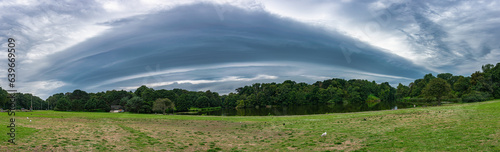 Panorama of a thunderstorm shelfcloud (arcus) over a lake in a nature area photo