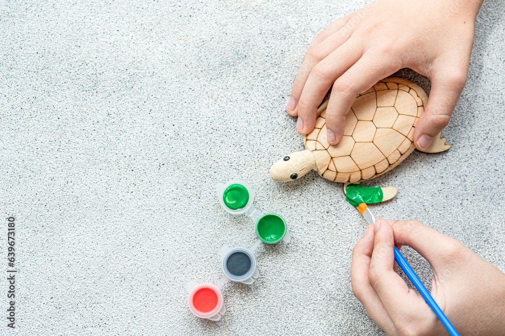 Kid's hands with turtle toy