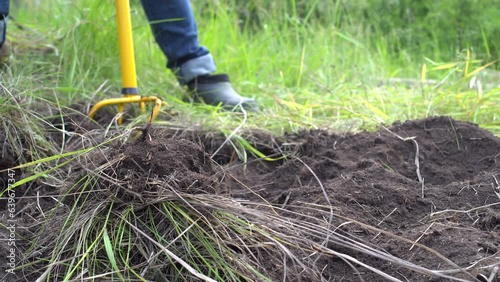 Female farmer using portable manual earth auger for prepare the soil for planting vegetables