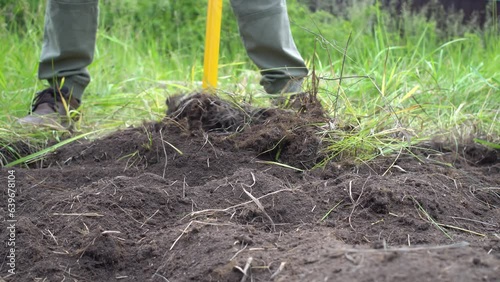 Male farmer using hand-held soil drilling cultivator tool for prepare the soil for planting vegetables
