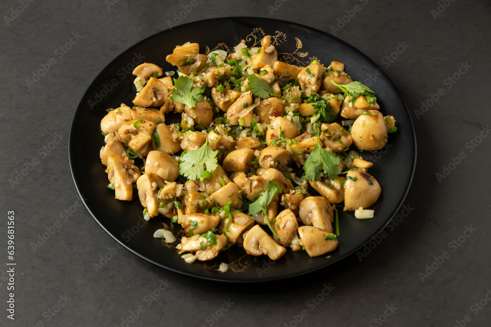 Garlic Mushroom fry served in dish isolated on background top view of bangladesh and indian food Garlic Mushroom fry served in dish isolated on background top view of bangladesh and indian food