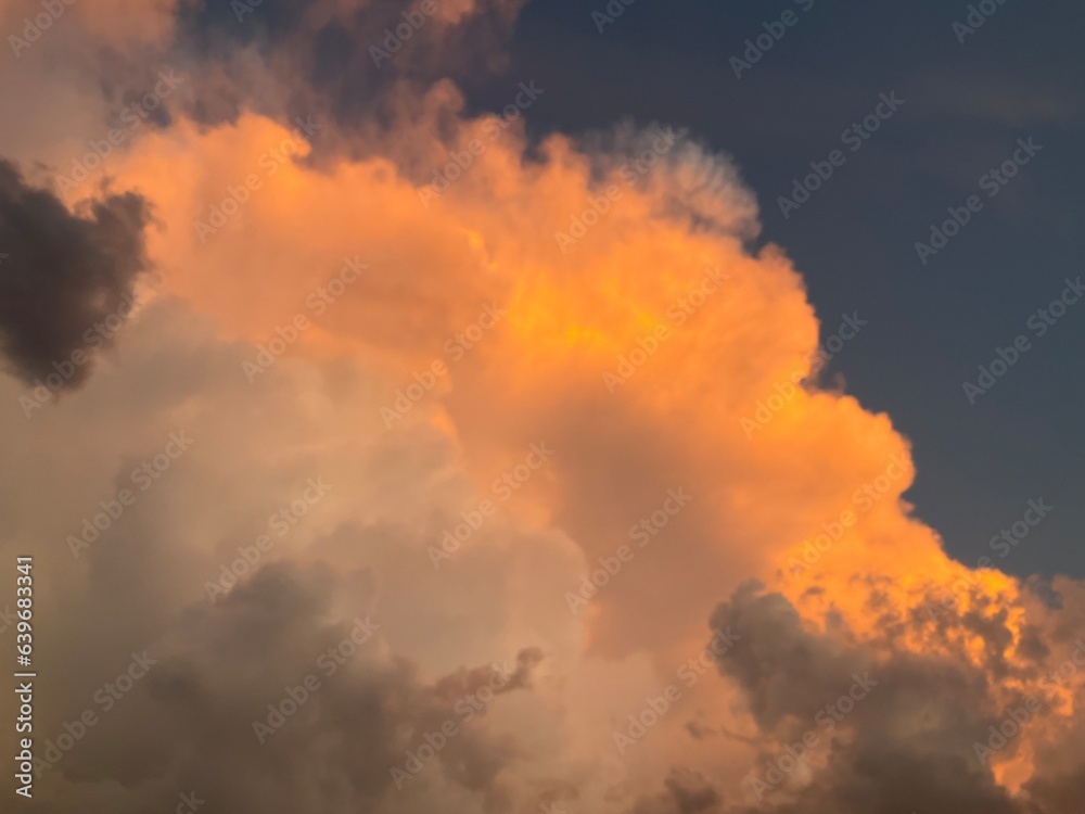 Sky with menacing storm clouds in different colors: orange, white and gray and dark. Topics: weather, meteorology, storm season, sky observation