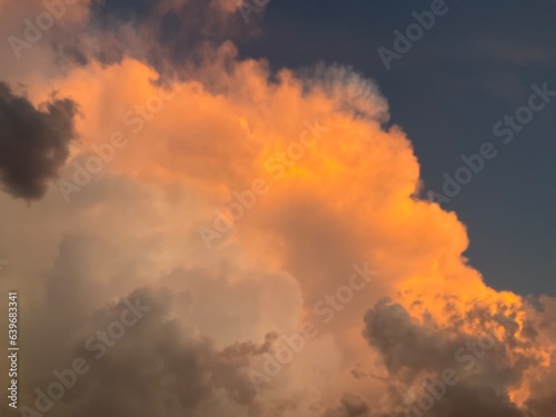 Sky with menacing storm clouds in different colors: orange, white and gray and dark. Topics: weather, meteorology, storm season, sky observation