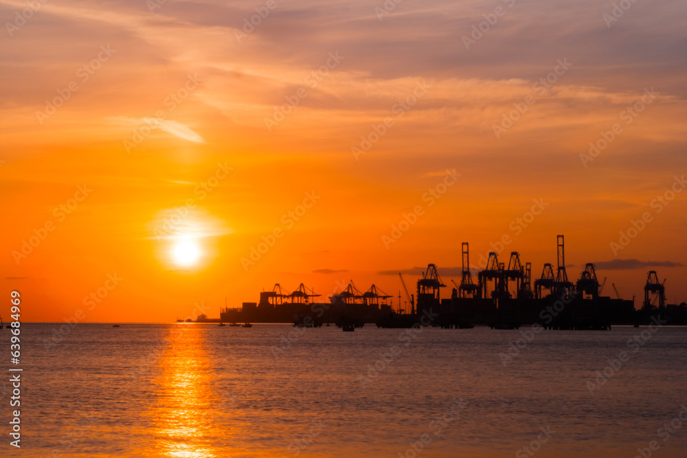 Breathtaking dramatic sunset sky with clouds and setting sun over the cargo port and the Sea of Marmara surface in the evening in Turkey. Cloudscape and summer concept