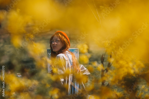 A woman standing in a field of yellow flowers and looking up