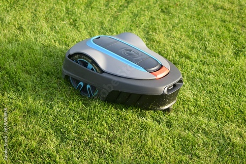 The lawnmower robot mows the grass in the garden.