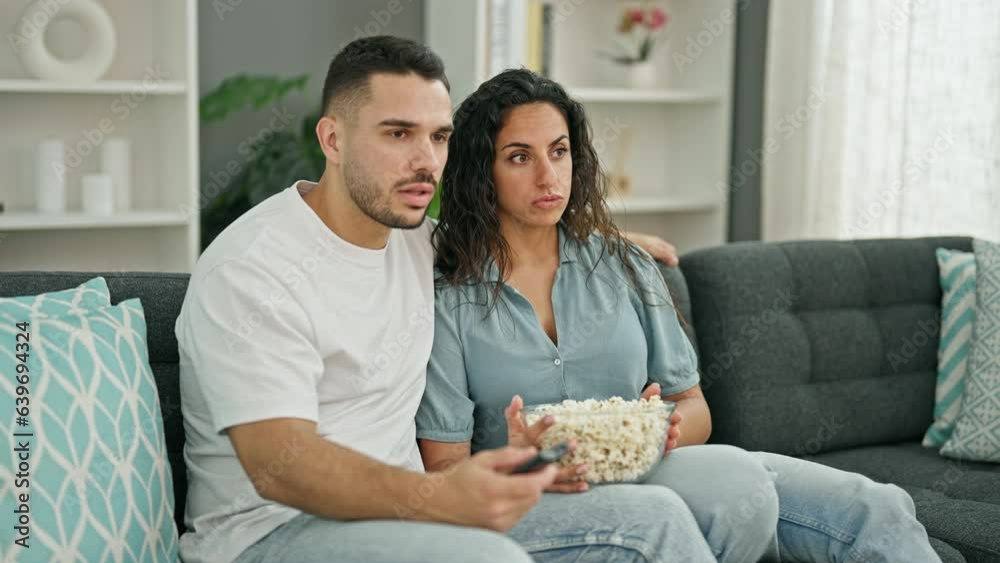 Man and woman couple watching soccer game celebrating at home Man and woman couple watching soccer game celebrating at home