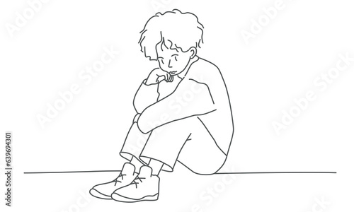 Sad, depressed boy sitting alone.