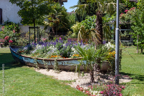 An old boat turned into a flower bed on the embankment photo