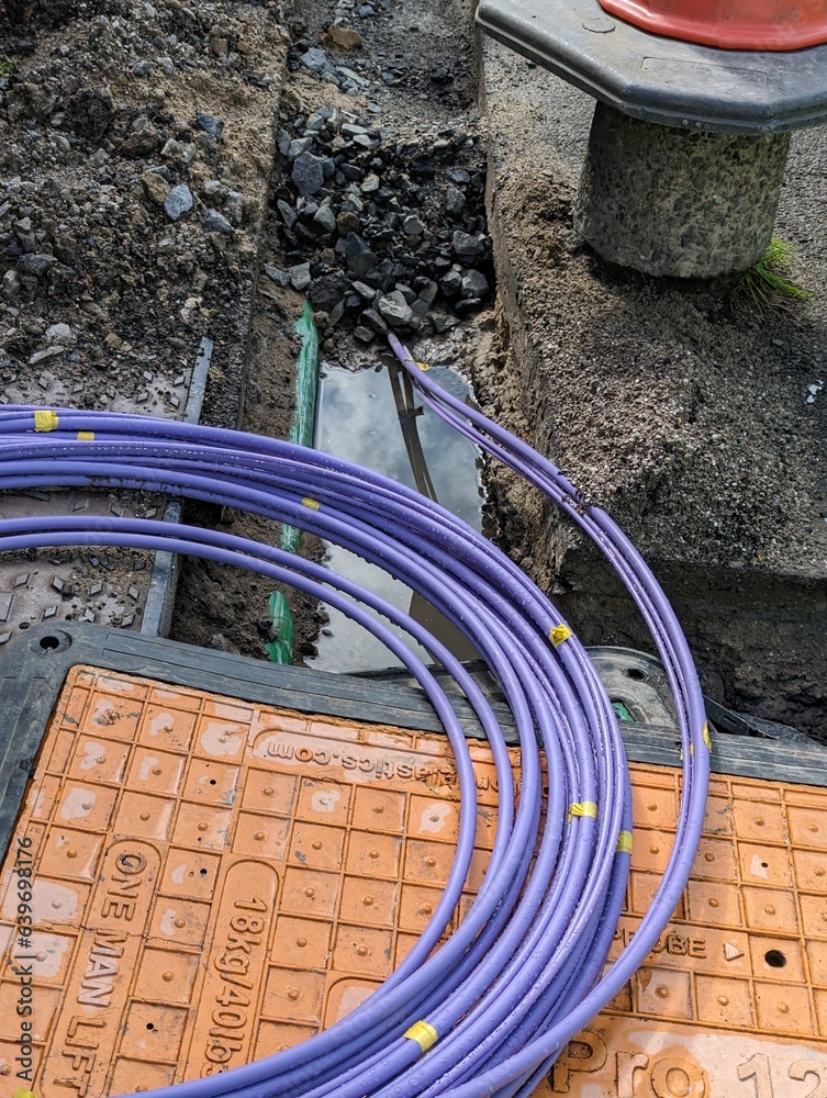 Fibre optic cable coming out of a trench curled up waiting to be