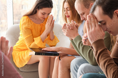 Group of people praying wit...