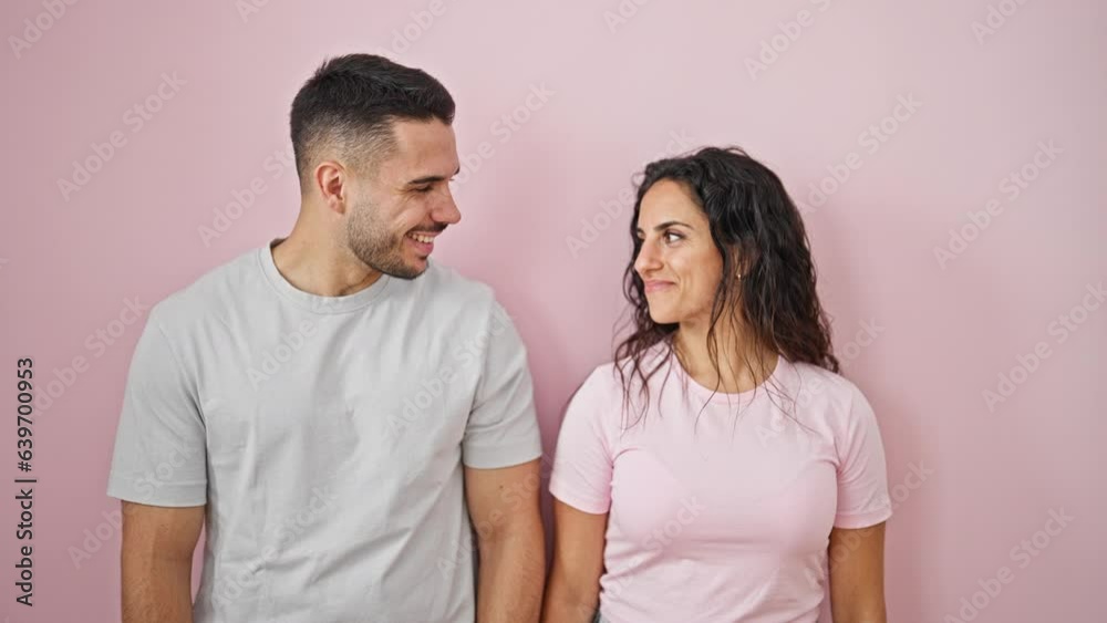 Man and woman couple smiling confident kissing over isolated pink background Man and woman couple smiling confident kissing over isolated pink background