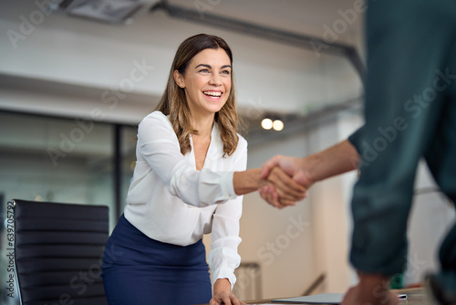 Fototapet Happy mid aged business woman manager handshaking greeting client in office