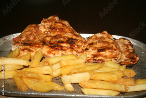 roasted chicken fillet with French fries on dark background ready for your projects